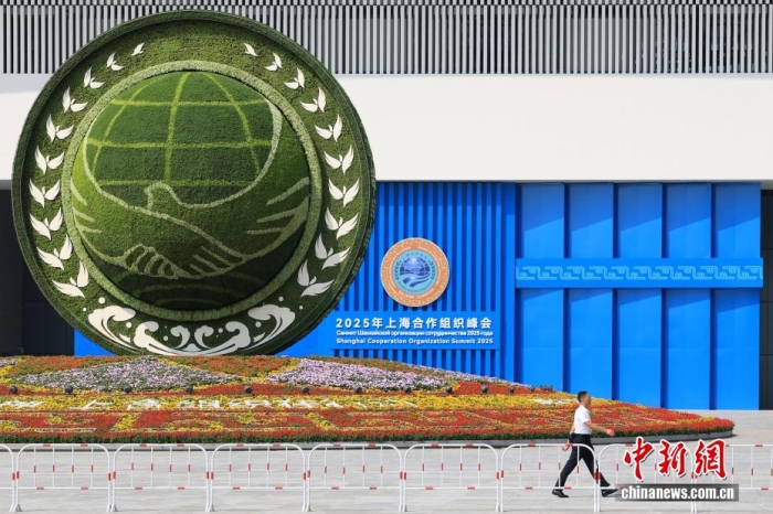 8月31日，天津，一名工作人員從2025年上海合作組織峰會(huì)主會(huì)場(chǎng)外的景觀花壇旁經(jīng)過。當(dāng)日，2025年上海合作組織峰會(huì)在天津舉行。<a target='_blank' href='/'><p  align=