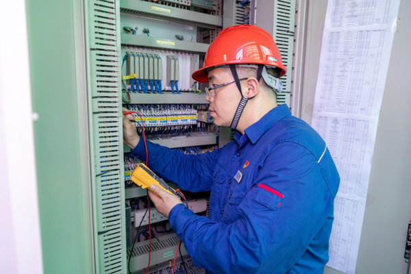 呂曉勇在保護盤柜前檢查二次回路接線情況。受訪者供圖