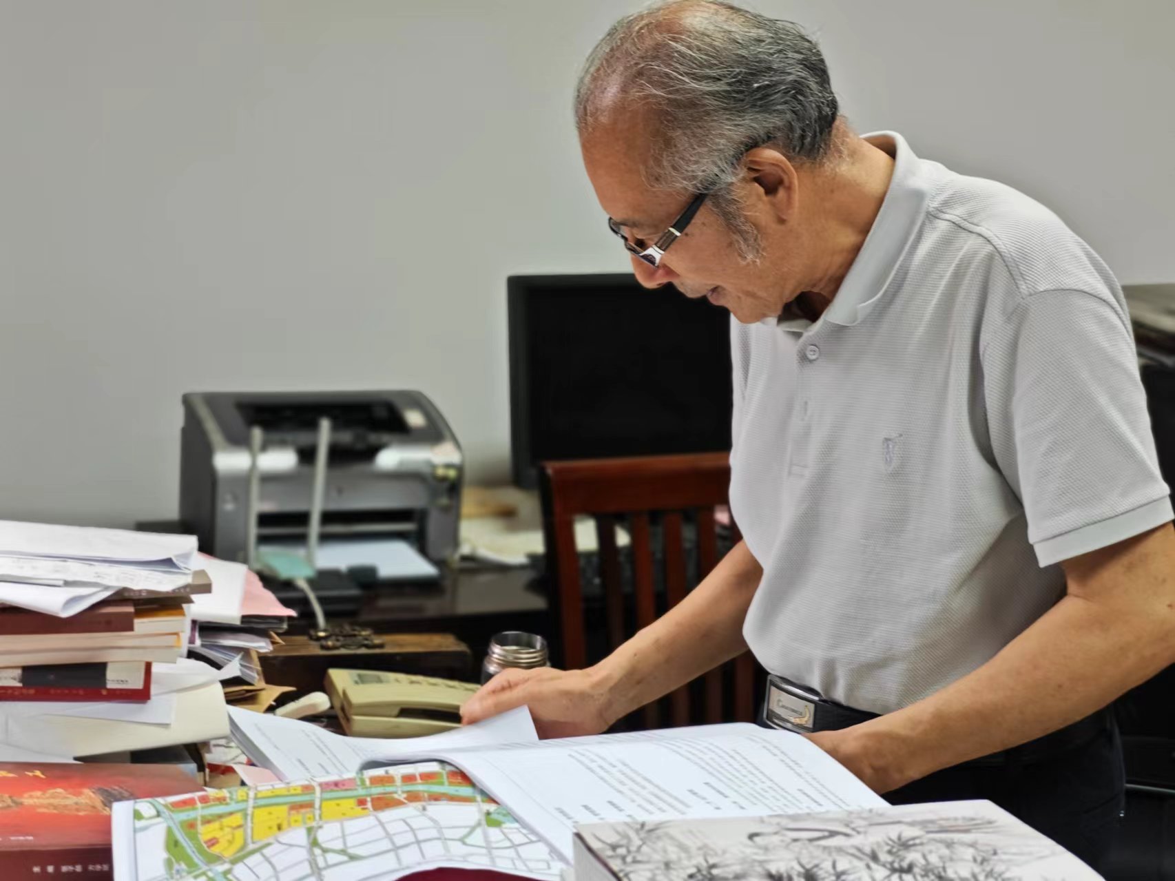 顧風(fēng)在辦公室翻閱資料。人民網(wǎng)記者 黃鈺攝