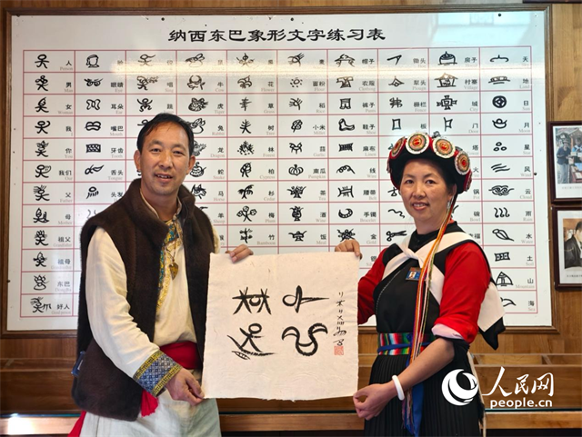 人民網(wǎng)“行進中國”云南調(diào)研采訪團走進麗江，和閏元現(xiàn)場用東巴文寫下“行進中國”。人民網(wǎng)記者 符皓攝