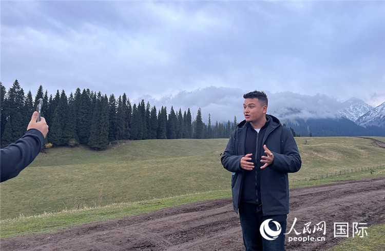 在庫爾德寧，吾買爾江被雪山美景震撼，即興錄制了短視頻作品。人民網(wǎng)記者曾書柔攝