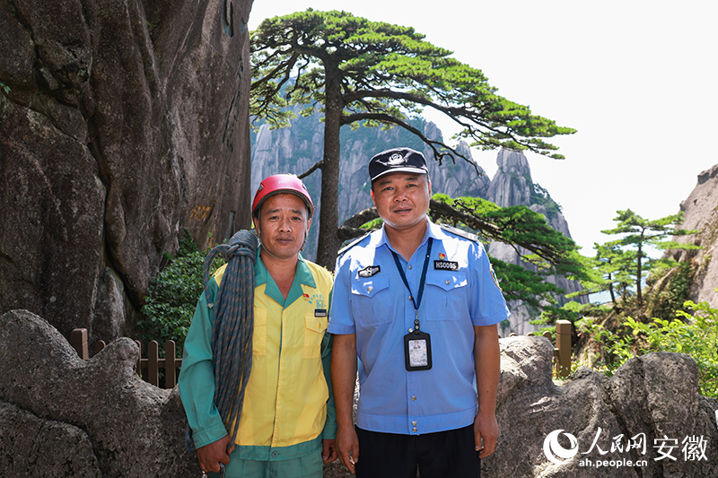 全國道德模范李培生（左）和胡曉春在迎客松前合影。人民網(wǎng)記者 張俊攝