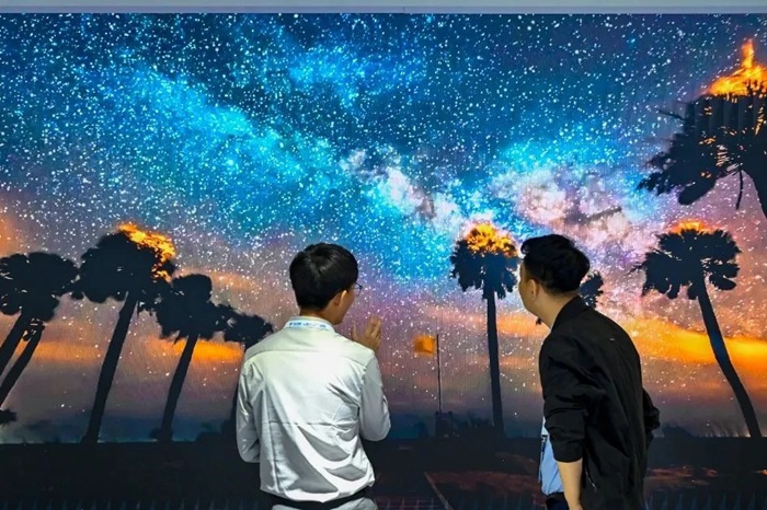 長春光博會希達(dá)電子展區(qū)，一位工作人員正在給一位觀眾講解。（長春新區(qū)供圖）