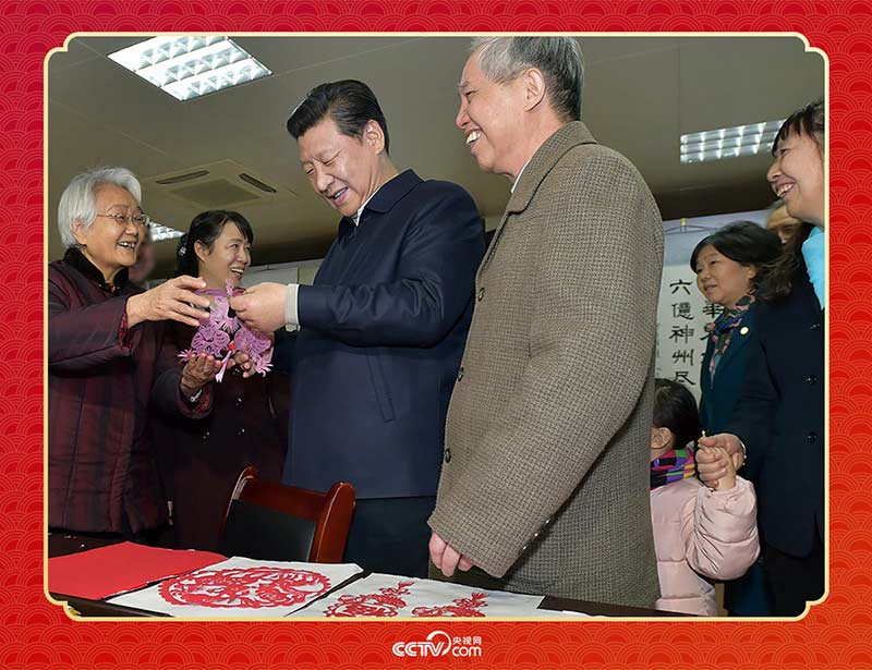 2015年2月15日，習近平在西安市雁塔區(qū)電子城街道二〇五所社區(qū)服務中心欣賞社區(qū)居民的剪紙作品。