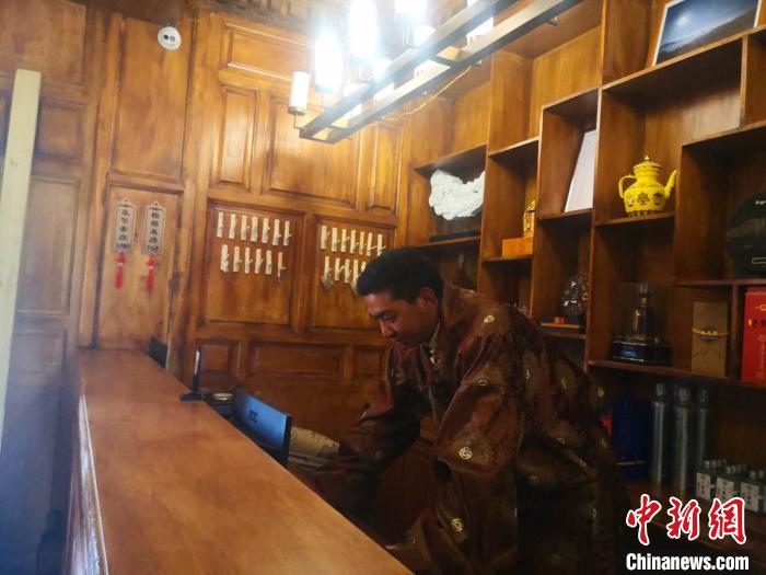 圖為桑杰才讓用電腦處理財(cái)務(wù)?！∈缝o靜 攝