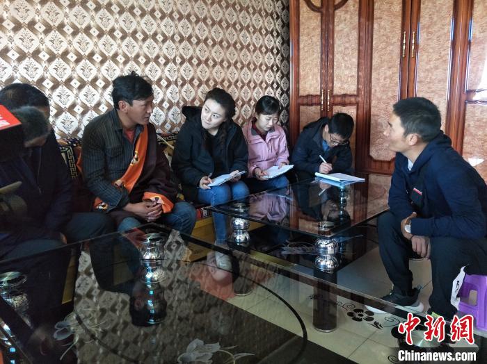 圖為調(diào)查組工作人員正在入戶調(diào)查?！∑钤鲚?攝