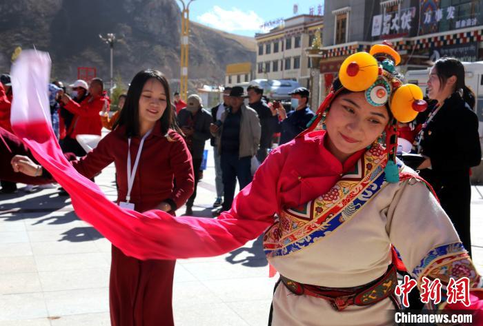 圖為中外記者向當?shù)孛癖妼W習民族歌舞文化?！?zhí)砀?攝