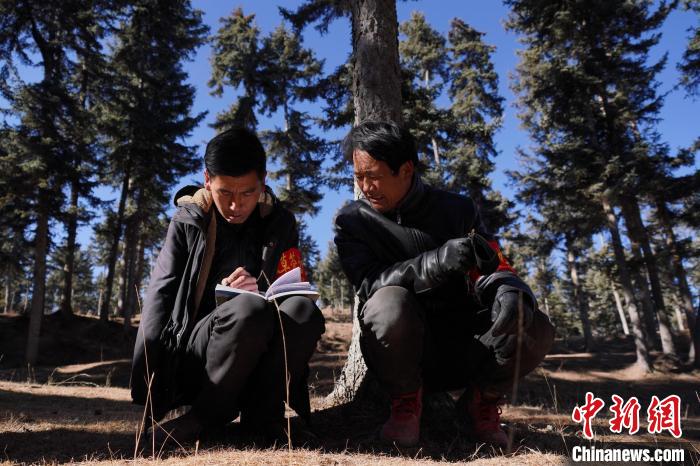 圖為桑杰加(左)和同事記錄巡查結(jié)果?！●R銘言 攝