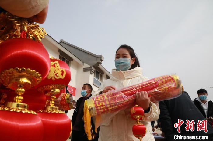 27日，蘭州新區(qū)為舟曲避險搬遷移民送“春節(jié)包”，楊周馬草前往領(lǐng)取，紅色寓意來年的日子紅紅火火?！∥航ㄜ?攝