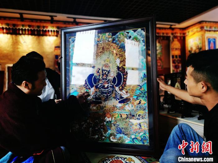 圖為久美尖措(左)與徒弟們展示唐卡作品。　張?zhí)砀?攝