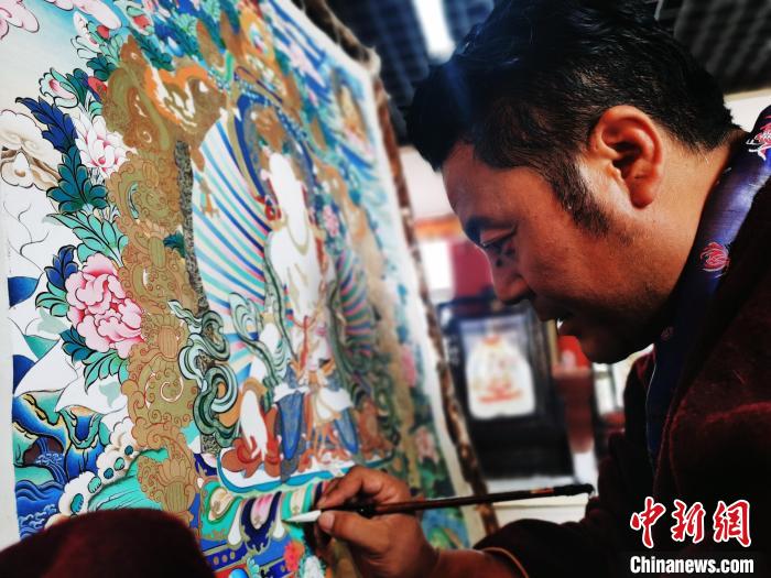 圖為久美尖措創(chuàng)作唐卡?！?zhí)砀?攝