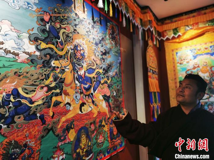 圖為久美尖措展示唐卡作品。　張?zhí)砀?攝