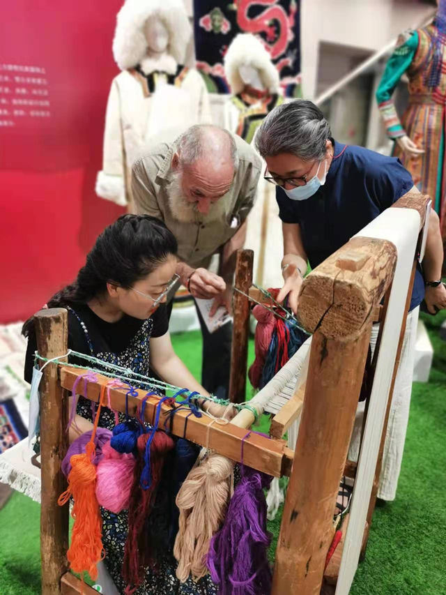 楊永良的學(xué)生在展會上向客商介紹加牙藏毯編織技藝。受訪者供圖