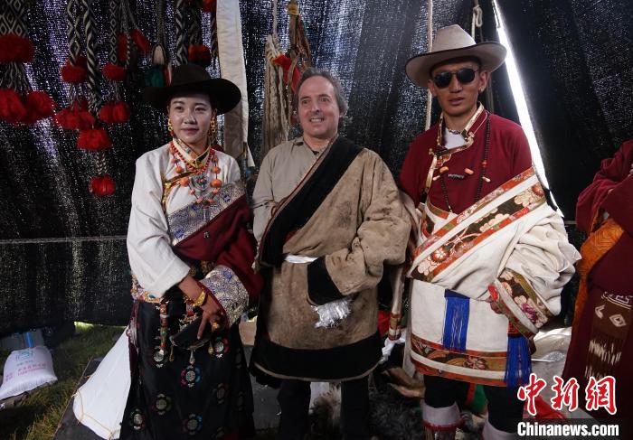 圖為一名外籍?dāng)z影師(中)身穿藏服和藏族民眾合影留念?！●R銘言 攝