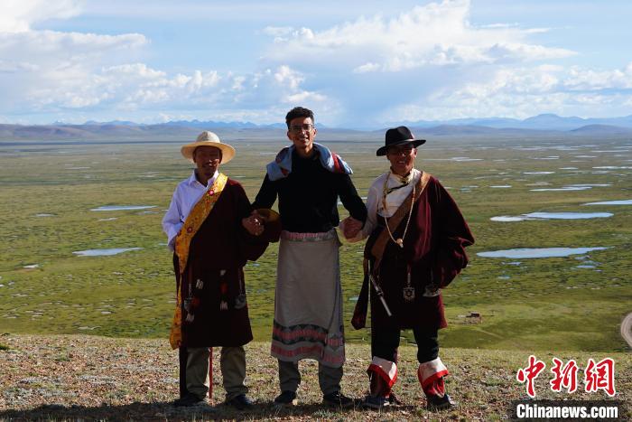 圖為一名留學(xué)生身穿自己國家的服飾和藏族民眾合影留念?！●R銘言 攝