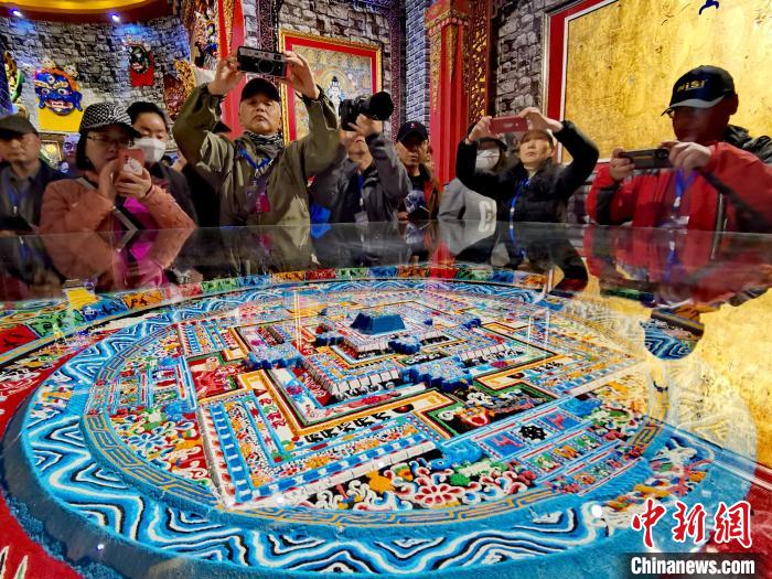 圖為參觀者拍攝壇城?！?zhí)砀?攝