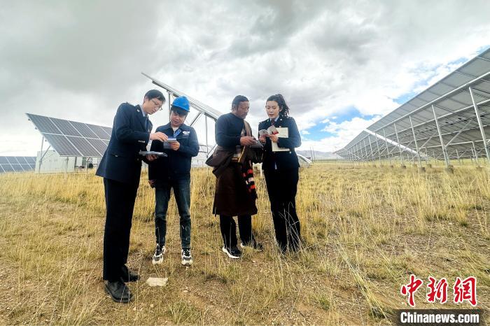 圖為稅務(wù)干部上門開展稅費輔導(dǎo)?！》劫F龍 攝