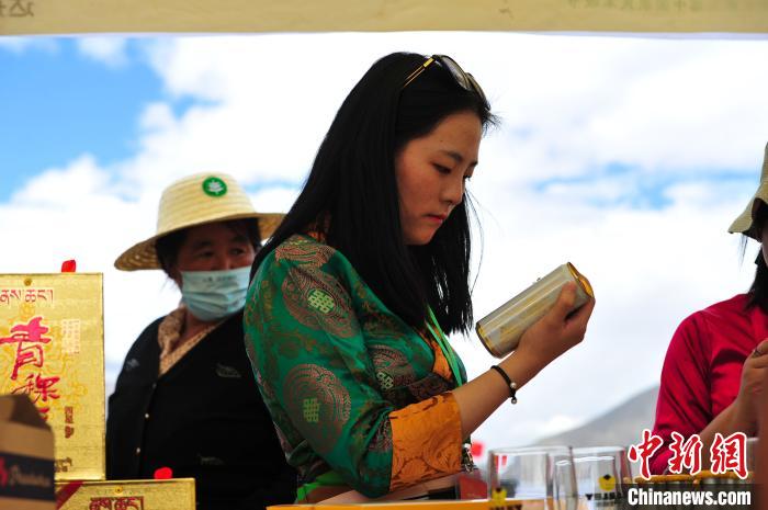 圖為拉薩市民在特色農(nóng)畜產(chǎn)品展示展銷會上選購商品?！垈?攝
