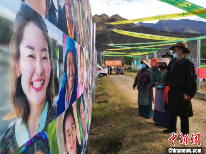圖為當?shù)孛癖娫谟^看展板上的笑臉?！垈?攝