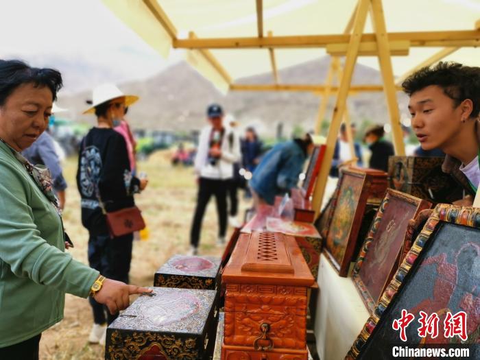 圖為拉薩市民在特色農(nóng)畜產(chǎn)品展示展銷會上選購商品?！垈?攝