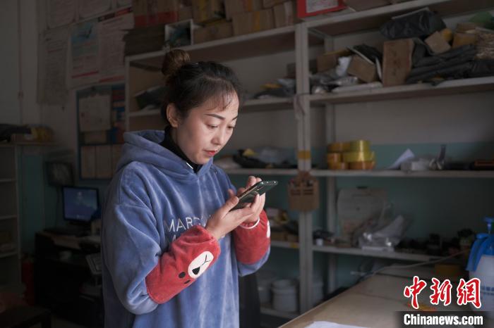 正在快遞站點(diǎn)內(nèi)忙碌的楊莉春?！『闻罾?攝