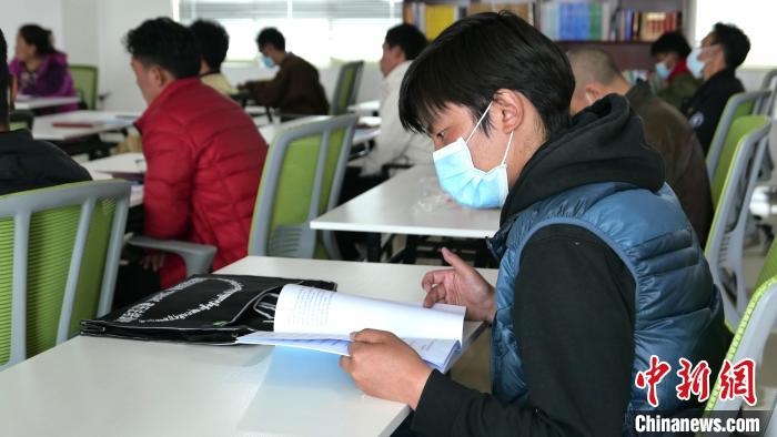 圖為正在閱讀“杰松達(dá)孜”藏歷法教材的學(xué)員?！≈x牧 攝