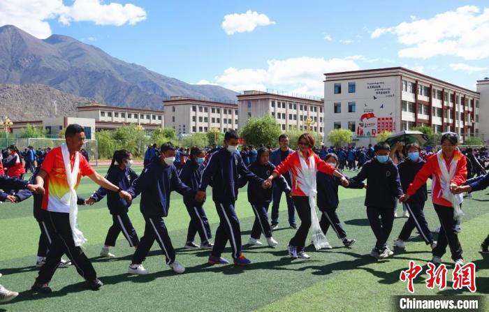 圖為世界冠軍與拉薩阿里地區(qū)高級中學學生一起跳鍋莊?！∪轿木?攝