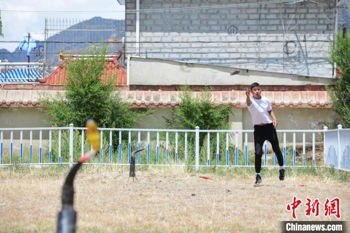 圖為西藏自治區(qū)拉薩市賽馬場(chǎng)內(nèi)市民在體驗(yàn)“打牛角”項(xiàng)目?！∝暩聛?lái)松 攝