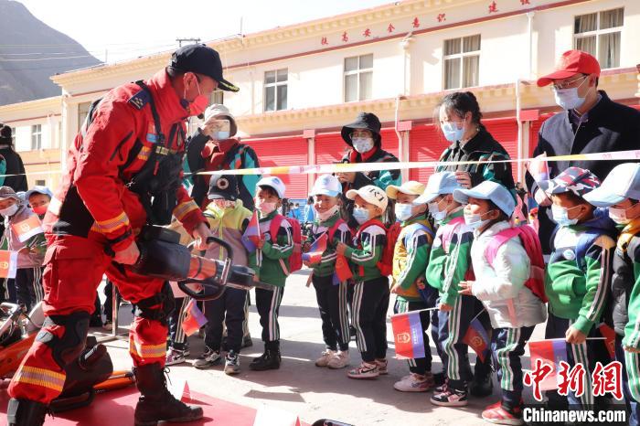 圖為消防指戰(zhàn)員為學(xué)生講解、演示先進(jìn)救援裝備。　趙琳 攝