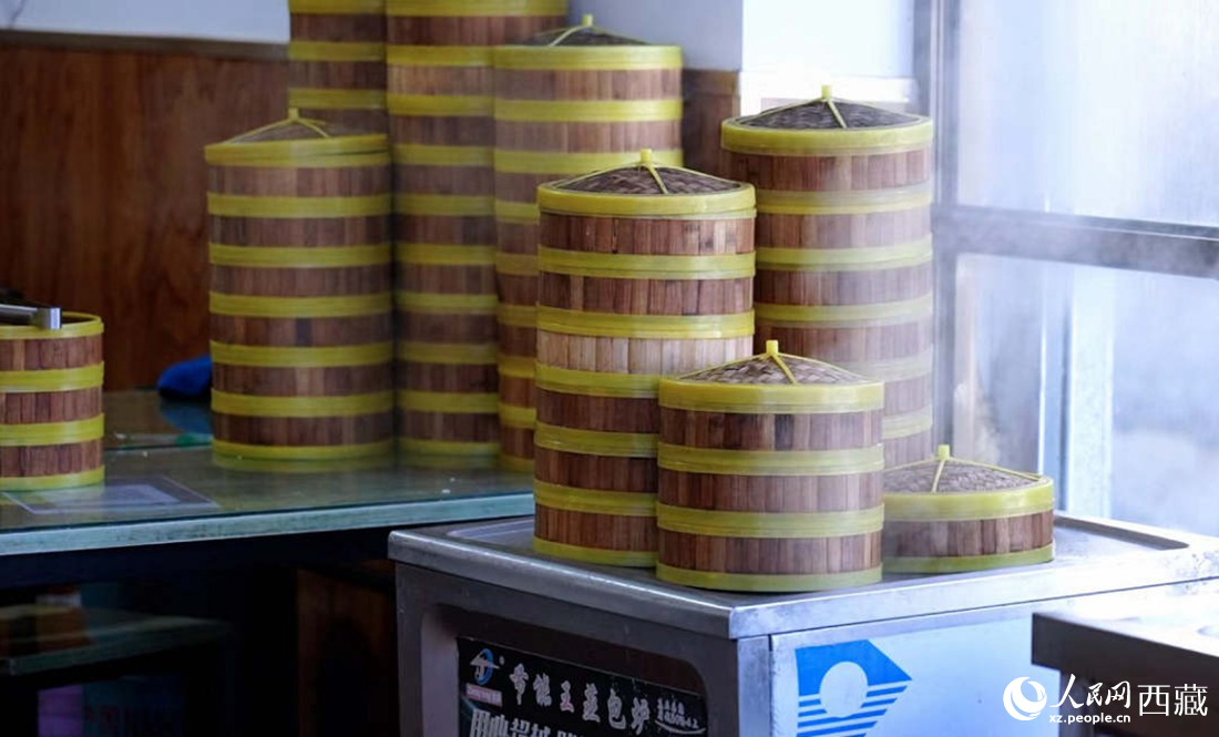 電蒸箱上擺滿了多屜熱氣騰騰的包子。人民網(wǎng) 次仁羅布攝