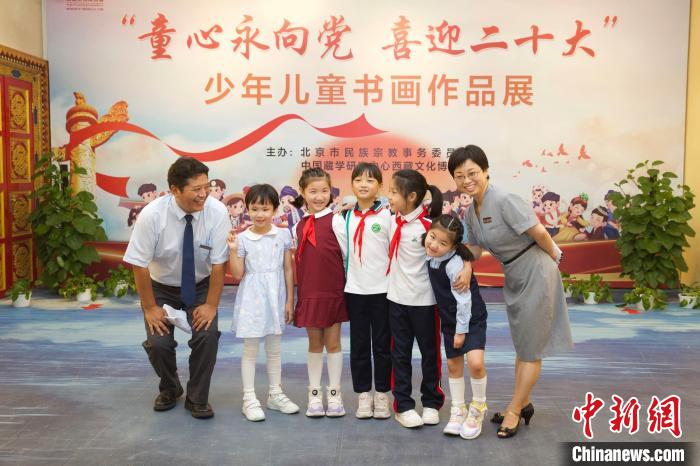 圖為與會嘉賓與入選畫作的“小作者”們在展覽上合影?！≈袊貙W(xué)研究中心供圖