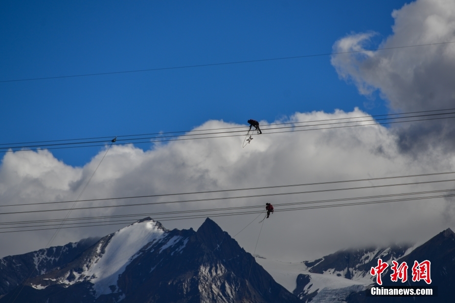 資料圖為2020年6月23日，西藏阿里聯(lián)網(wǎng)工程施工人員在日喀則希夏邦馬雪山附近進(jìn)行走線作業(yè)，安裝絕緣設(shè)備。 <a target='_blank' href='/'><p  align=