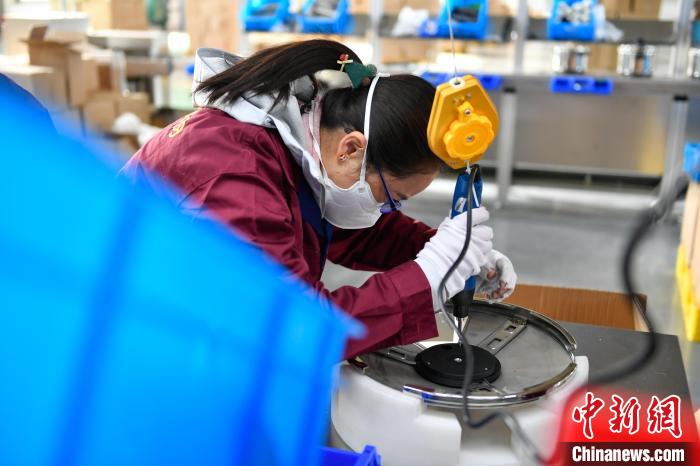 圖為工人正在組裝炊具。　貢嘎來松 攝