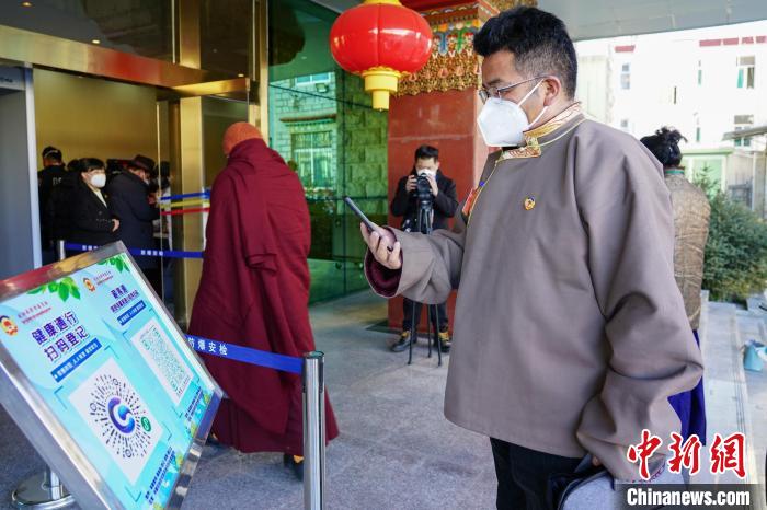 圖為政協(xié)委員掃場所碼進入會場?！〗w波 攝