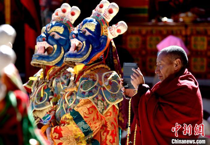 2月19日，正在拍攝跳神活動的僧人?！±盍?攝