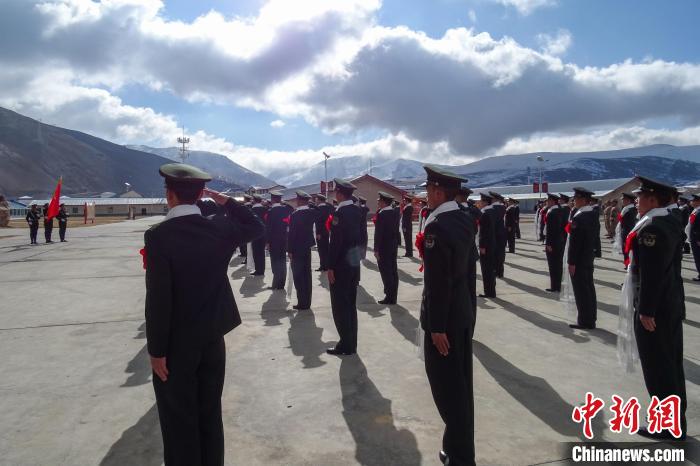 雪山下，退役士兵向軍旗敬軍禮。　李學(xué)文 攝