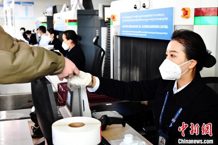 圖為機(jī)場(chǎng)工作人員為旅客辦理行李托運(yùn)?！≈芎?攝