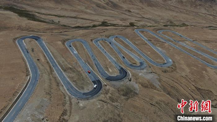 圖為騎手前往珠峰大本營途經(jīng)108道拐?！∮文恋厍蚬﹫D