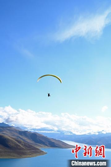 圖為在羊卓雍錯(cuò)，游客體驗(yàn)高空滑翔?！≮w朗 攝