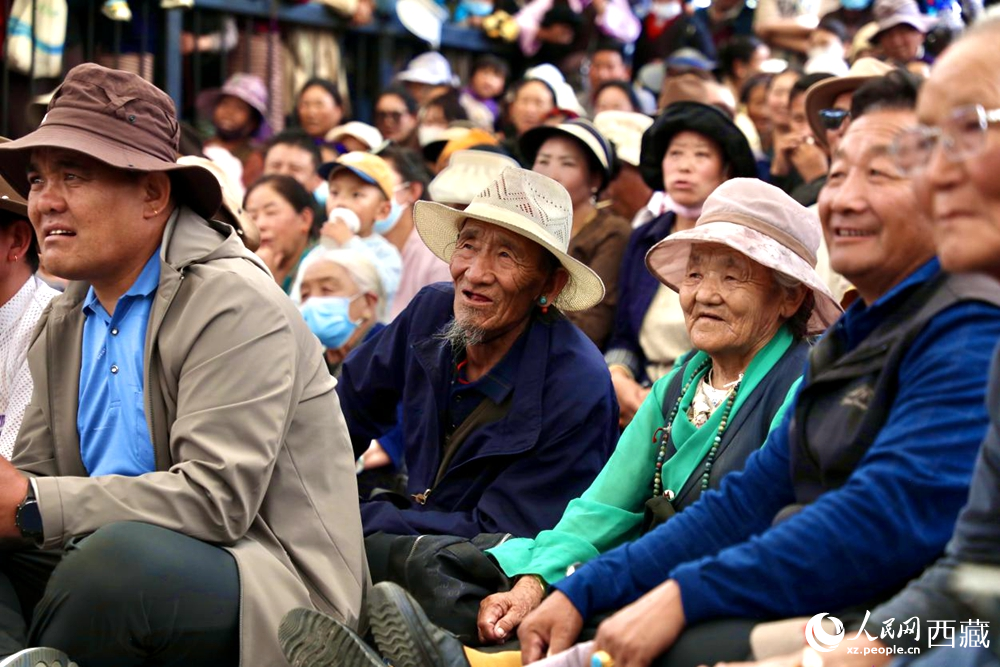 當(dāng)?shù)厝罕姾陀慰陀^看藏戲演出。