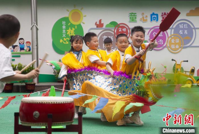 圖為龍舟賽游戲上，小伙伴們打鼓加油?！《^生 攝