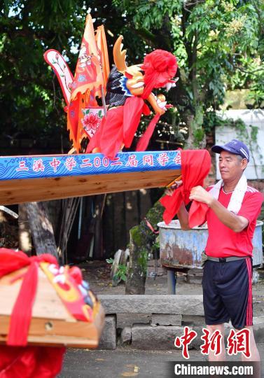 圖為5月29日，長樂江田鎮(zhèn)村民為即將入水的新龍舟系紅布?！埍?攝