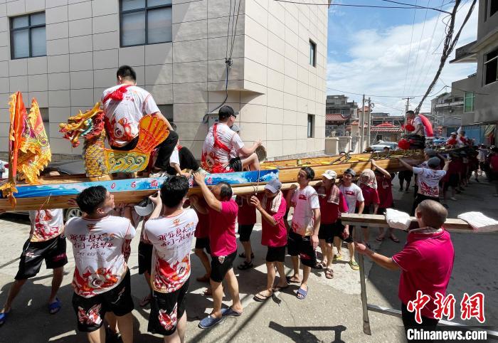 圖為5月29日，長樂江田鎮(zhèn)村民們肩扛著新龍舟舉行入水前游街儀式?！埍?攝